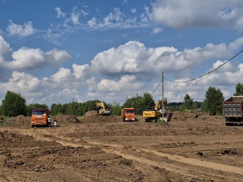 Земляные работы на площадке, экскаваторы и самосвалы